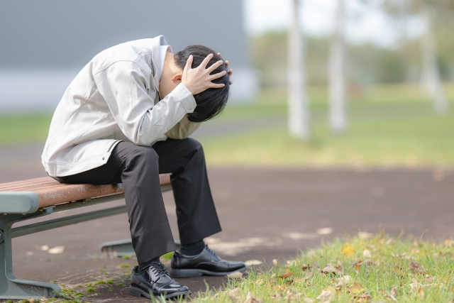 悩む作業着の男性　イメージ画像